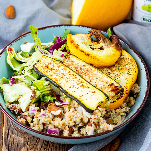 Eine blaue Schale mit Couscoussalat und einer Flasche Traubenkernöl der Firma Vitis Traubenkern GmbH.