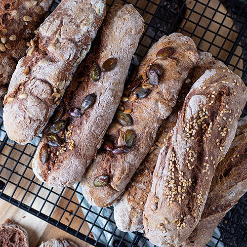 Mehrere Kornspitze mit verschiedenen Körnern als Topping auf einem dekorativen Backgitter.