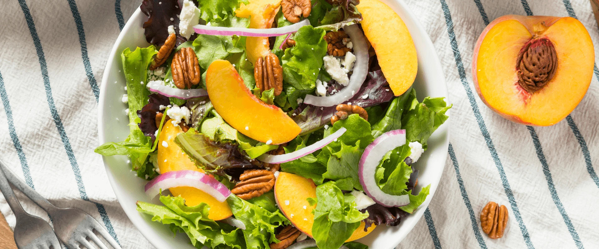 Ein bunter Salat mit frischen Pfirsichen in Nahaufnahme.